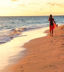 Woman walking on tropical beach at sunrise